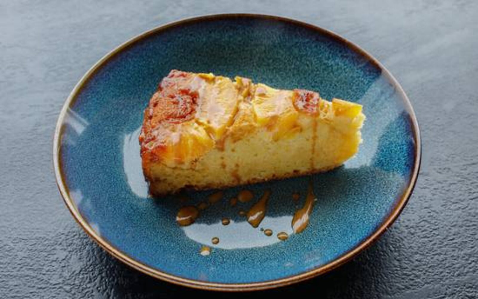 Une part de gâteau maison dorée, servie sur une assiette bleue