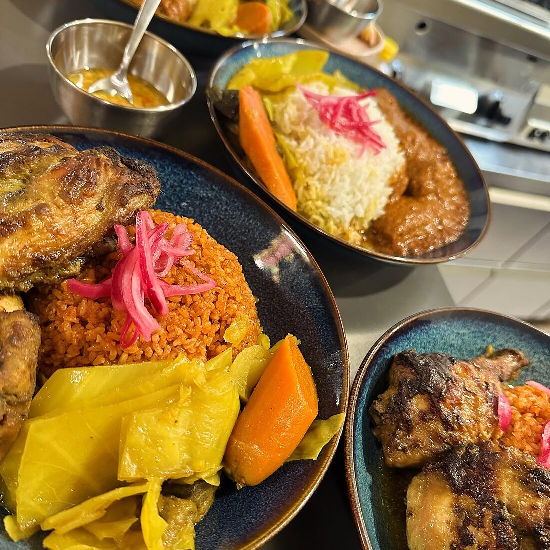 Assiettes servies près du comptoir : poulet, riz, plantain et carottes